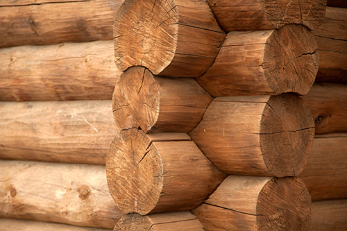 Close-up of a corner of an old wooden house with round logs